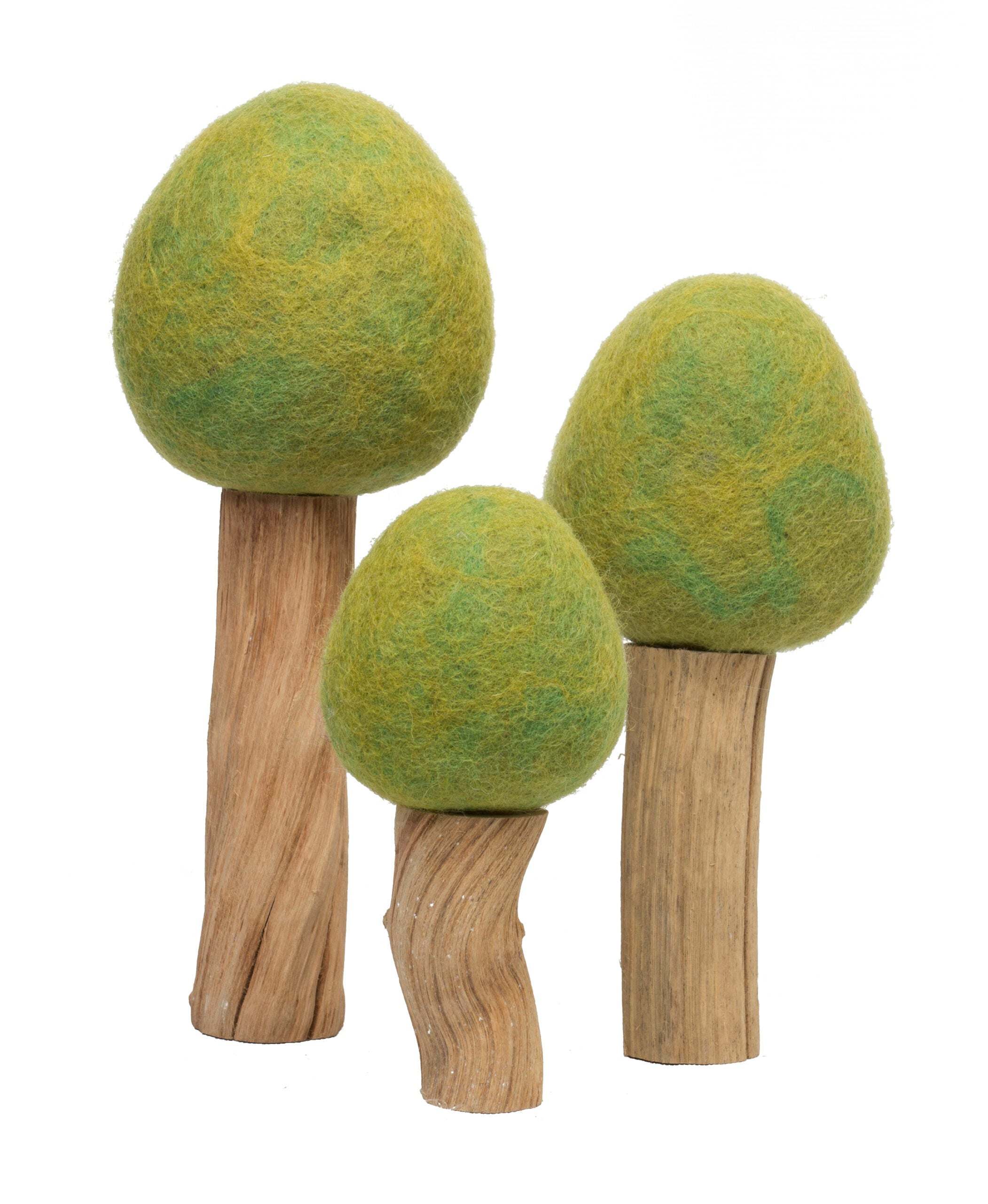 Three artisanal toy trees with textured green wool tops and natural wooden trunks of varying heights.