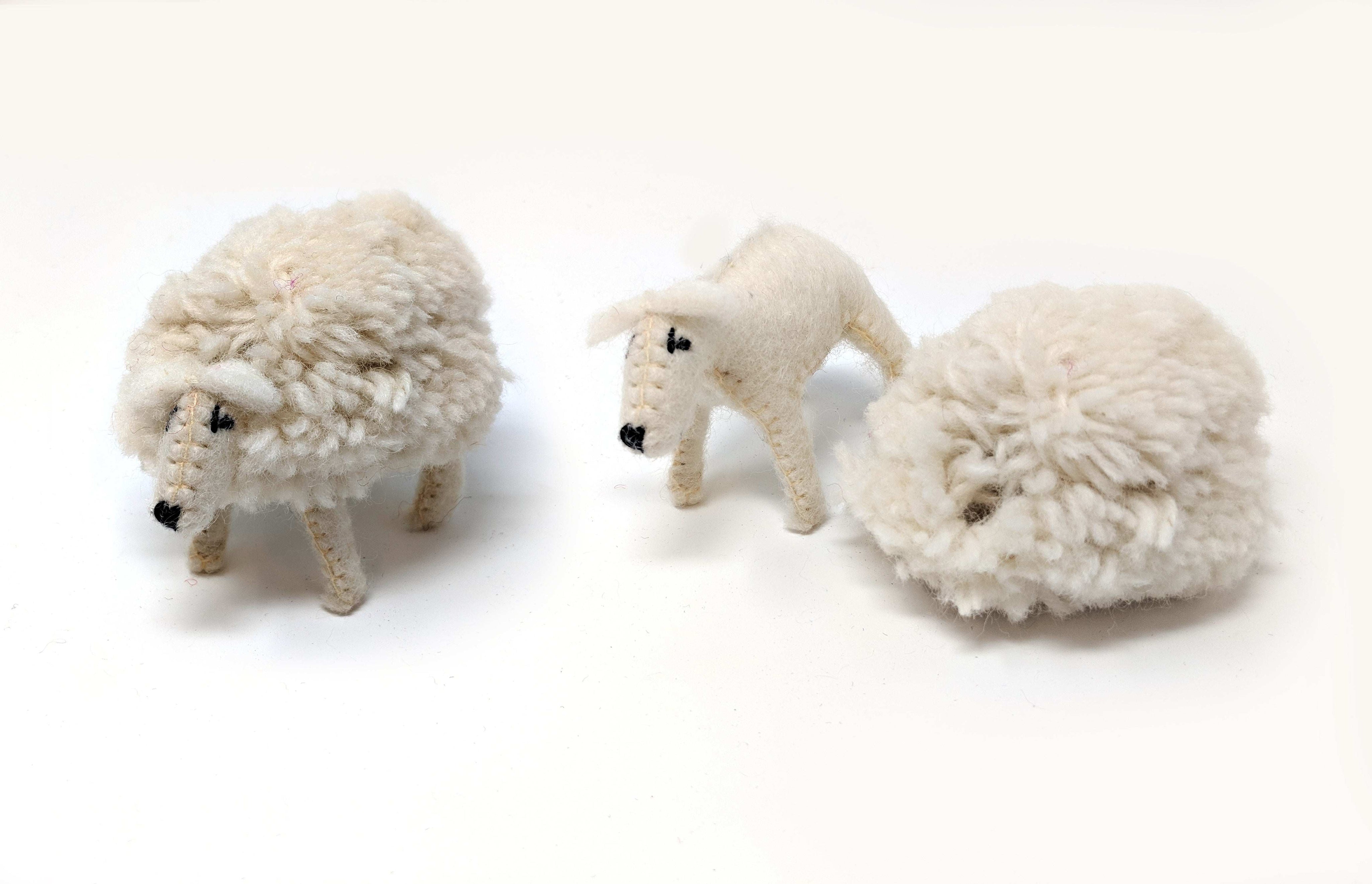 Handmade felt sheep toy with a removable woolly coat next to a shorn sheep figure on a white background.