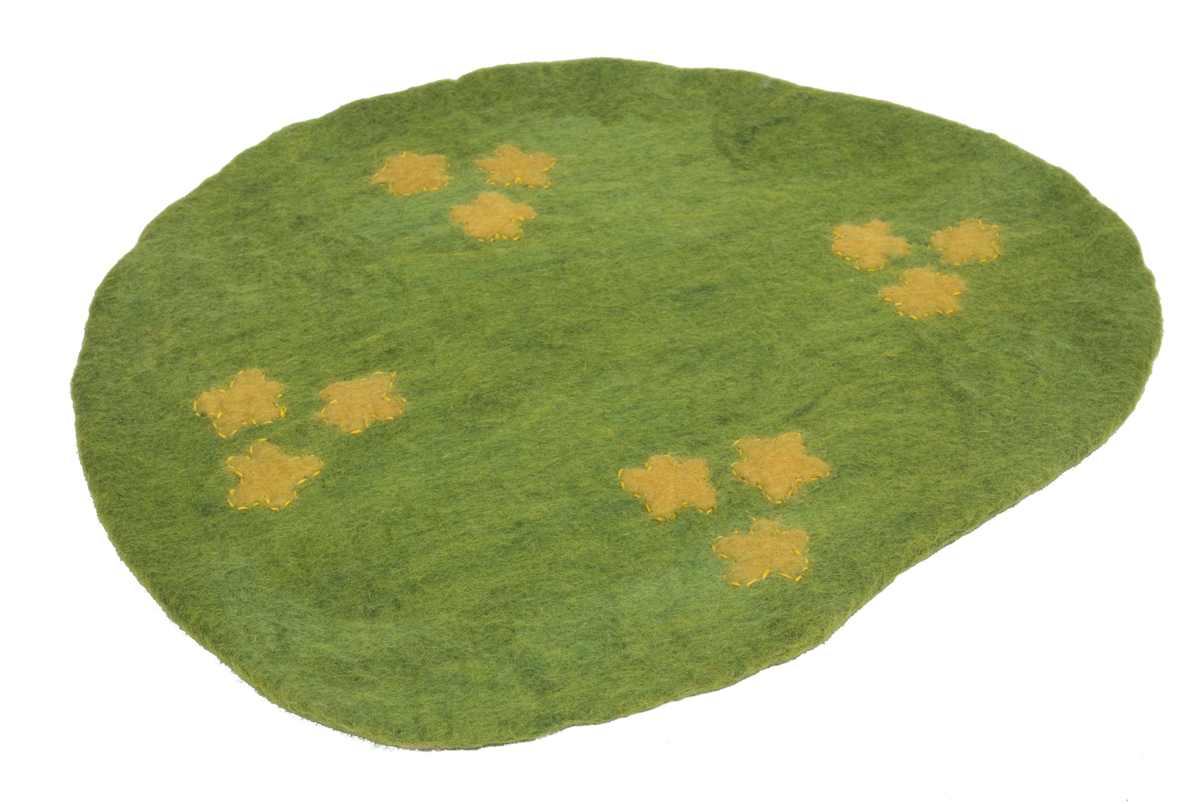 Green felt wool playscape mat with yellow stitched flower accents for sensory play and early childhood learning.