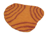 Irregularly shaped orange wool playscape mat with textured dark red concentric line patterns for sensory play.