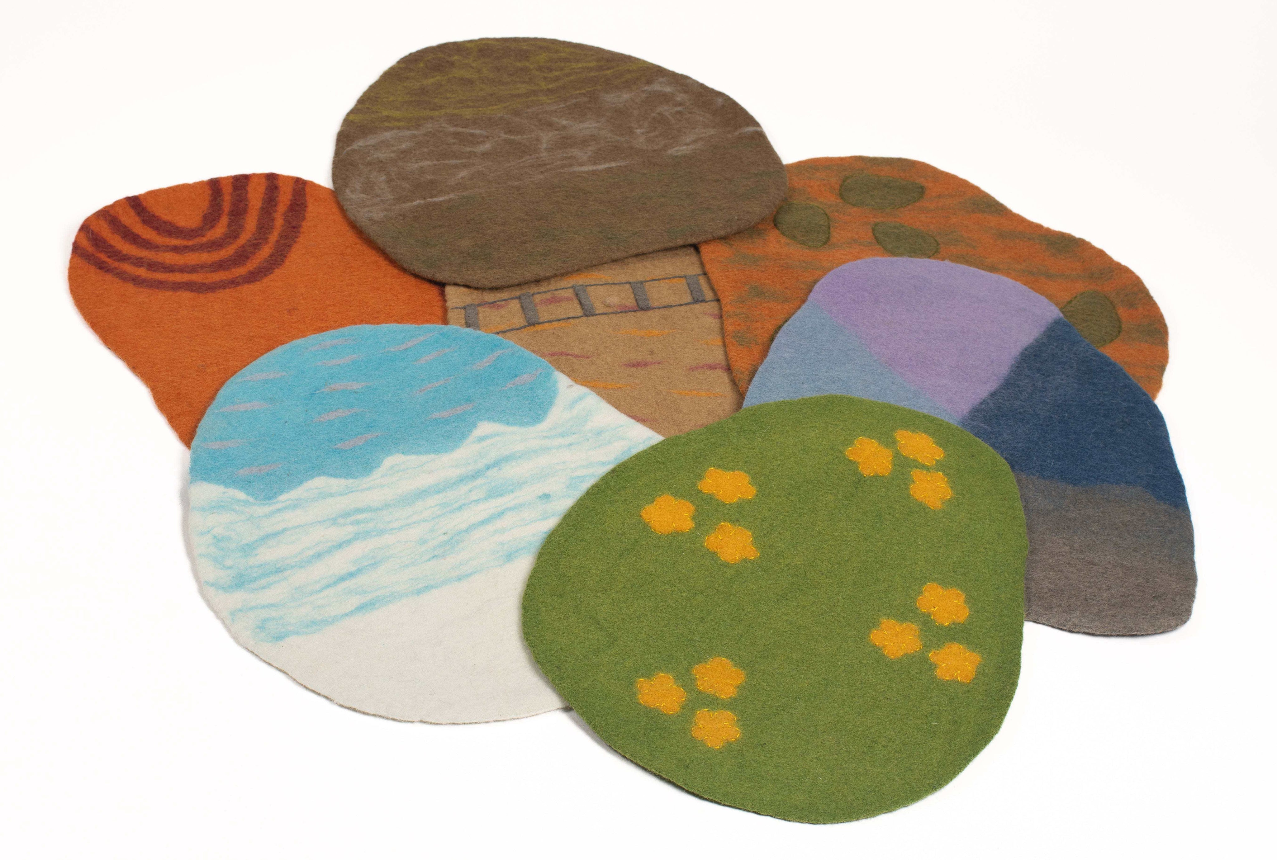 Colorful felted wool playscape mats with nature-inspired textures and patterns for sensory learning.
