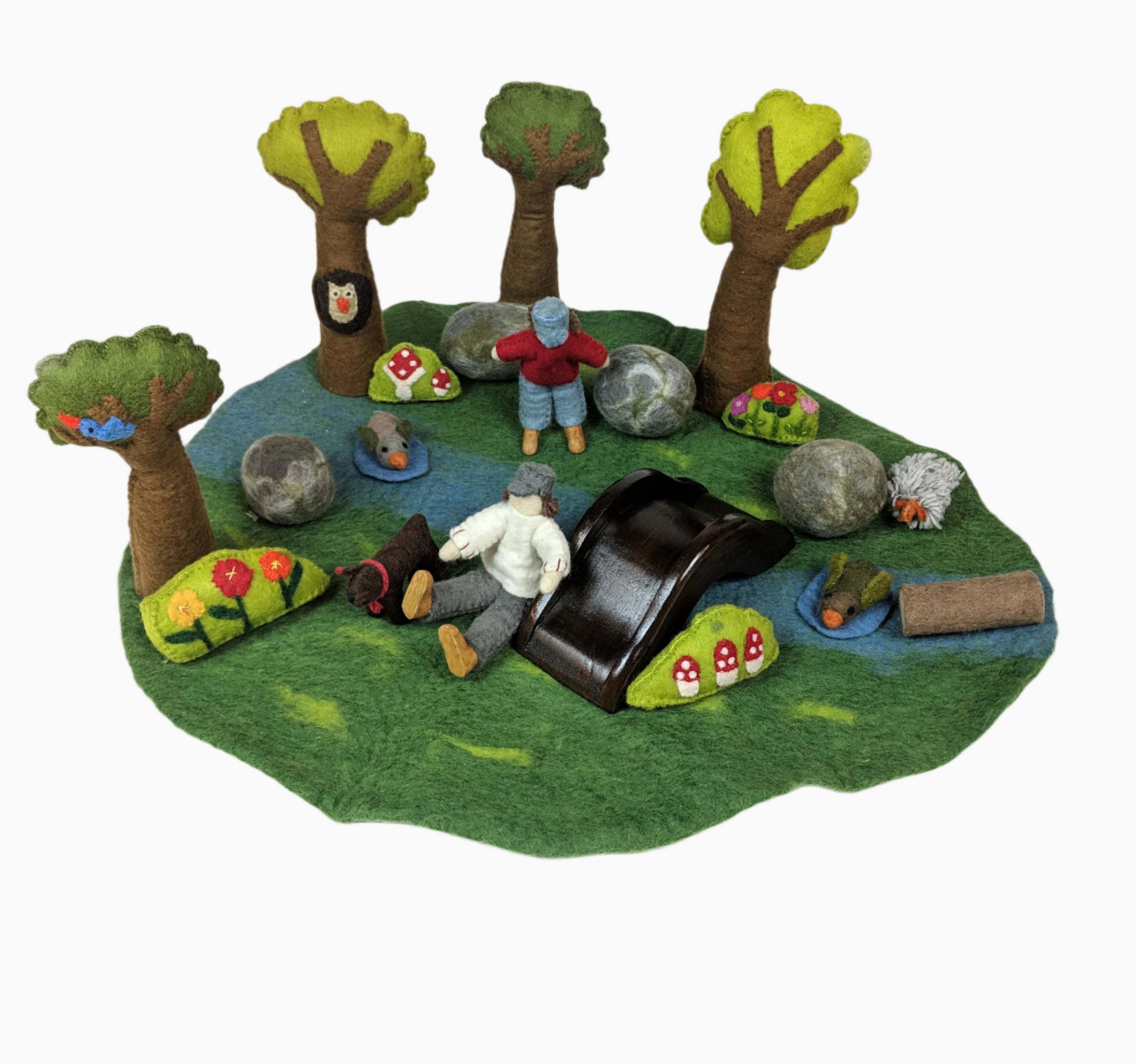 Hand-crafted felt wool river playset with trees, figures, animals, and a wooden bridge on a green grass mat.